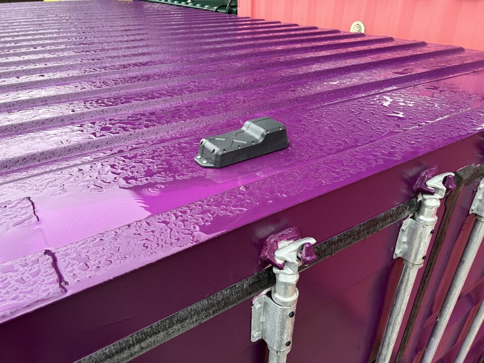Andromeda Tracker by INCYT mounted on a purple shipping container, showcasing an innovative tracking and monitoring solution for logistics and shipping.